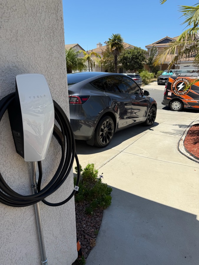 Level 2 EV charger installed beside a parked electric car